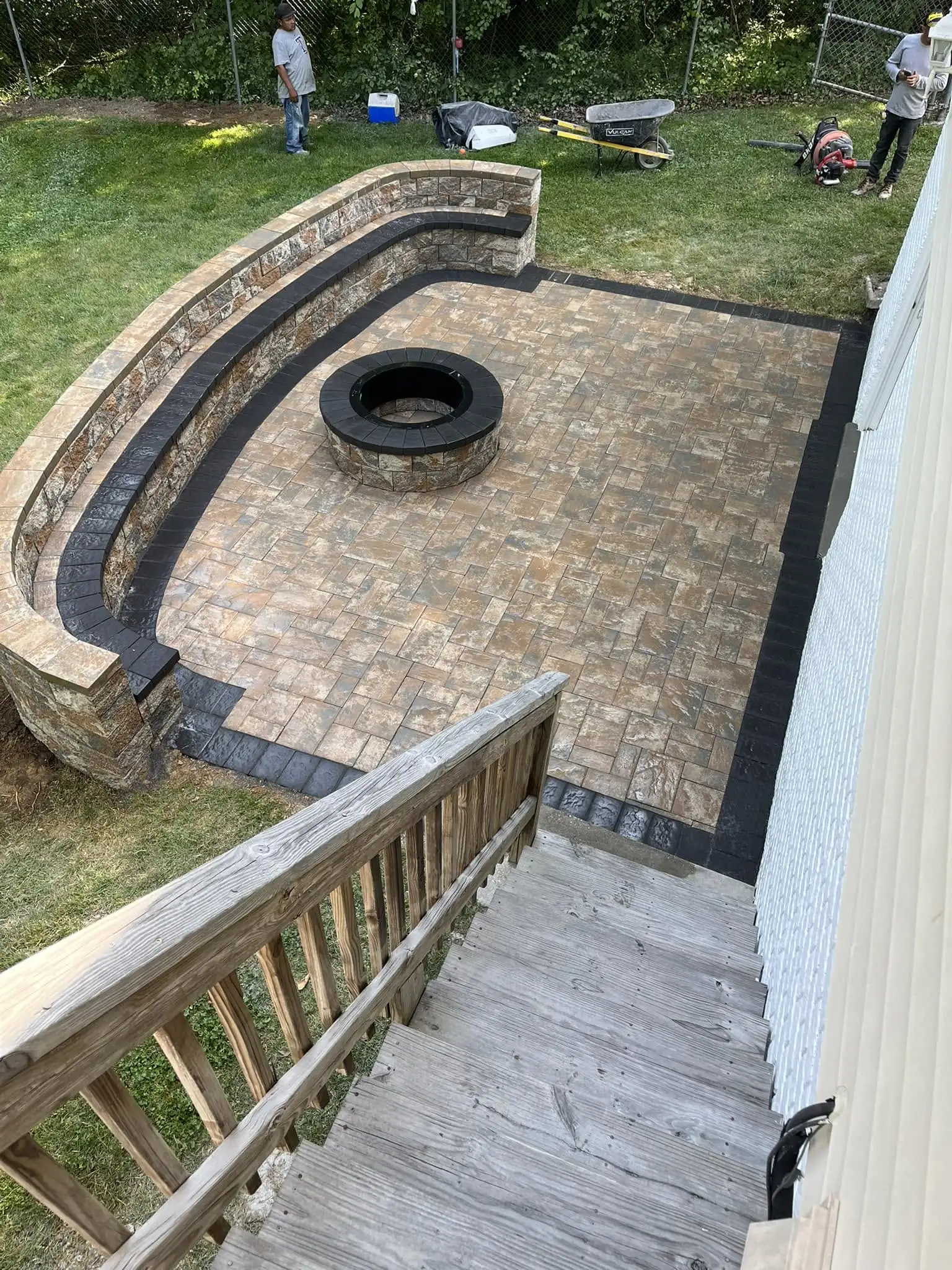 Stone patio with circular fire pit and curved seating wall